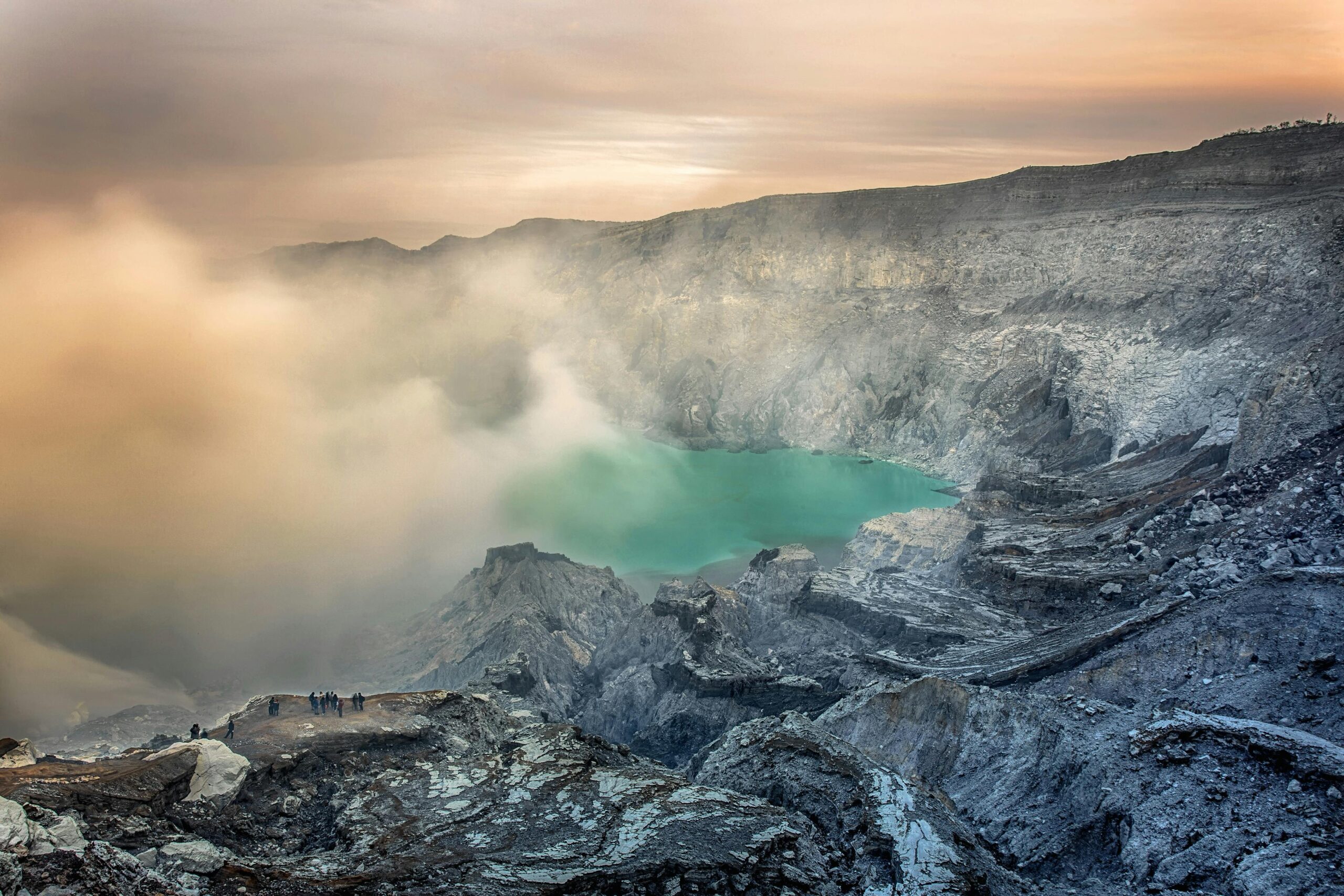 Captivating sunrise view of the Ijen crater with turquoise lake and volcanic landscape in Indonesia.